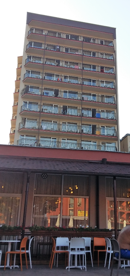 Tall hotel building with balconies overlooking an outdoor restaurant terrace in Sunny Beach Bulgaria