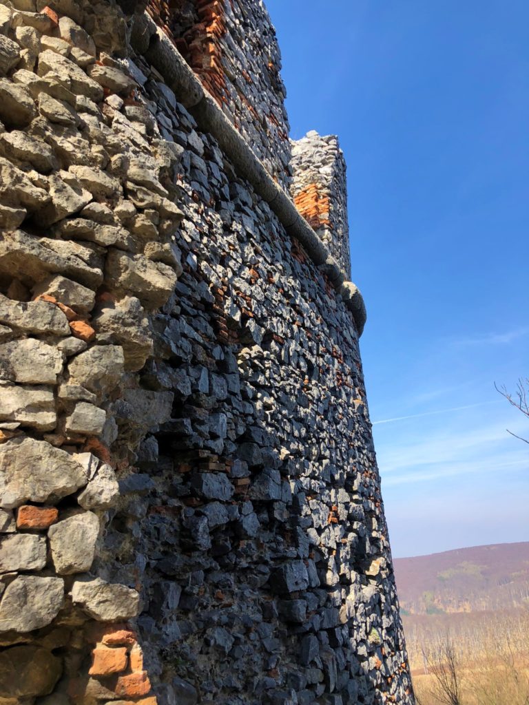 Ancient stone wall of a ruined castle against a clear blue sky