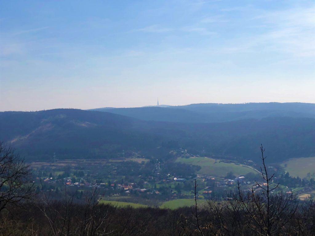Distant view of a valley town nestled between rolling forested hills