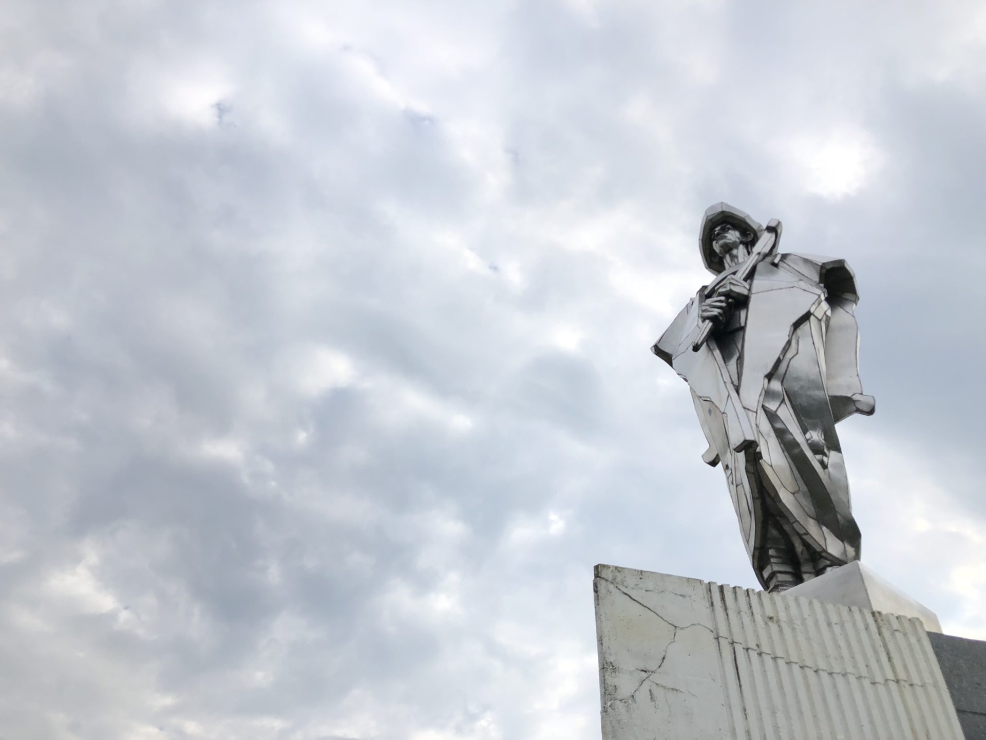 Large metal statue of Juraj Jánošík in Terchová against a cloudy sky