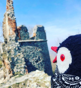 A plush toy looks toward the stone ruins of a castle