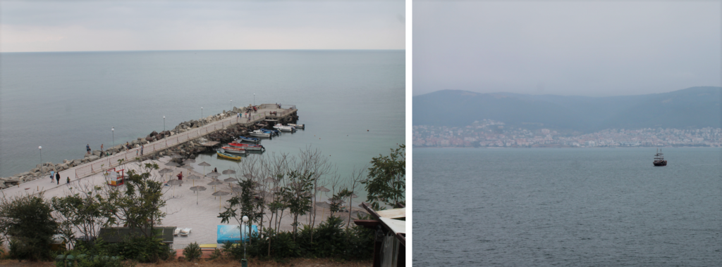 A pier with boats and a distant ship near the coast of Nessebar