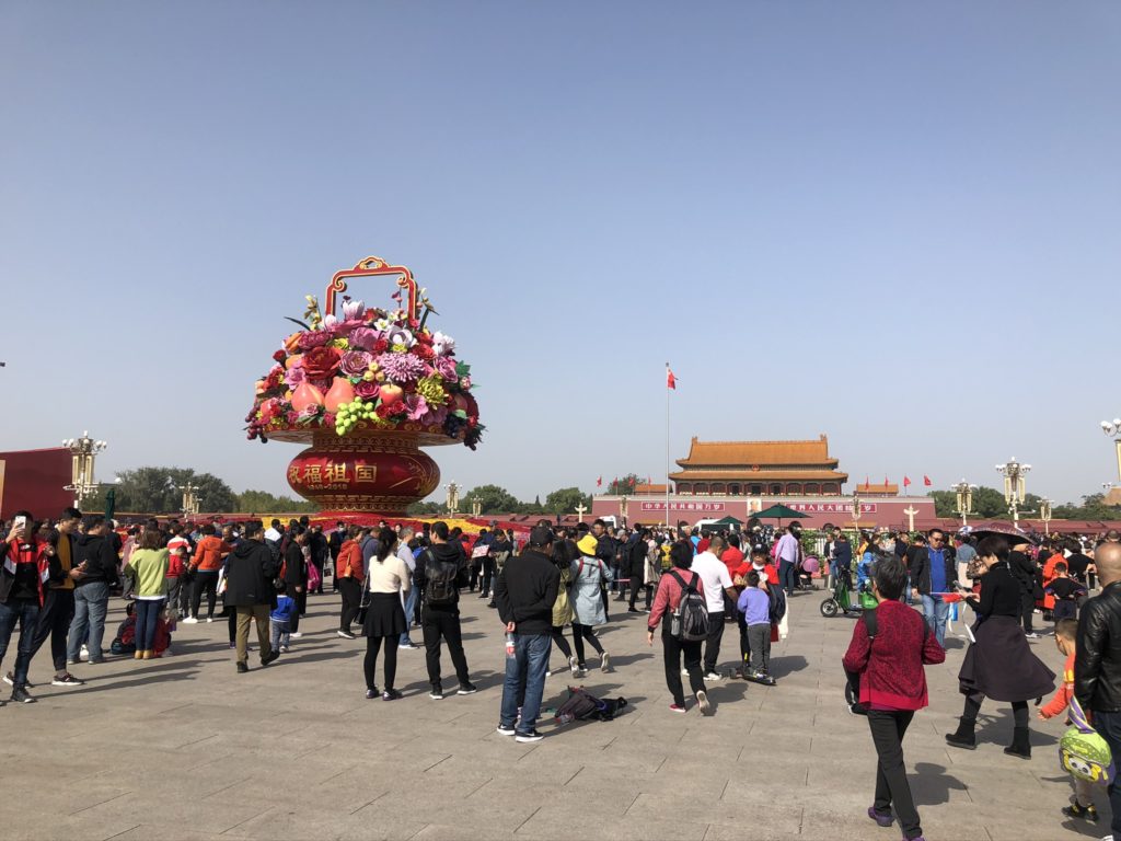 Crowds gather in Beijing near a large decorative flower basket display
