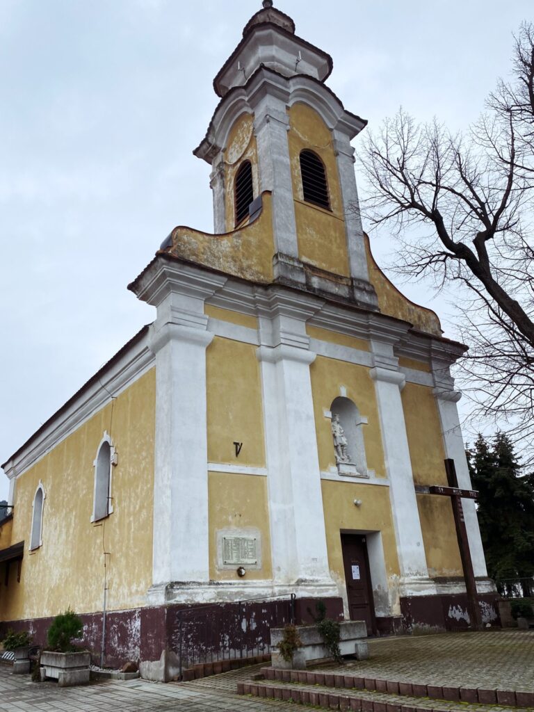 Yellow and white church with a tall tower in Plavecký Mikuláš