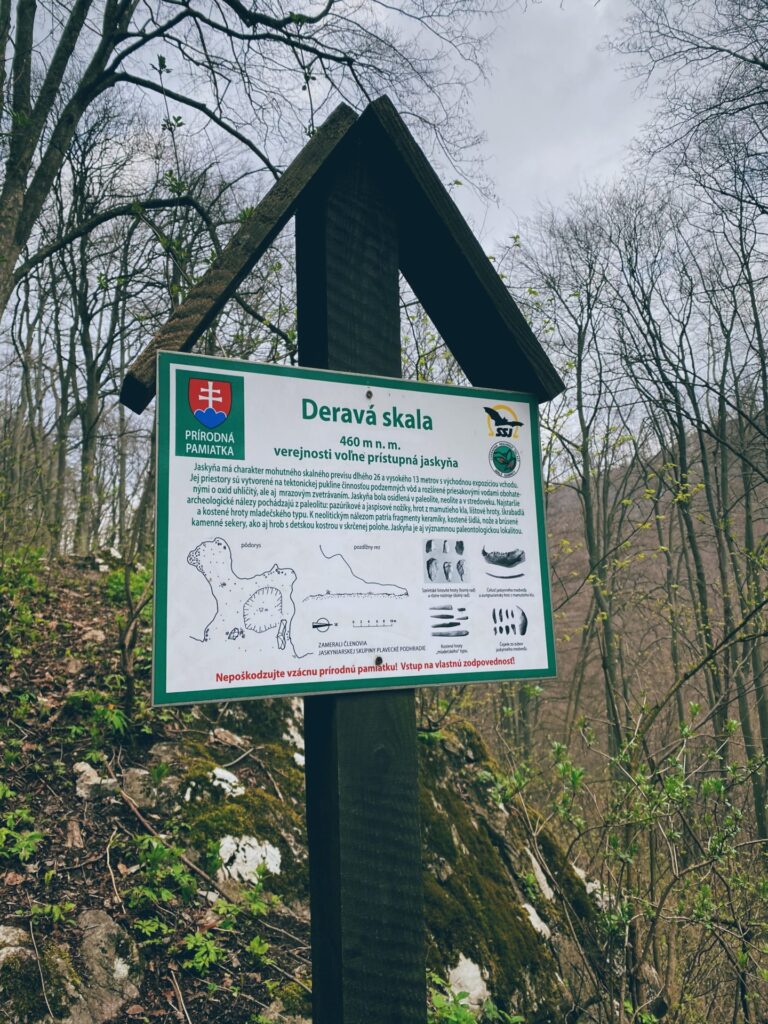 Informational sign about Deravá skala cave on a trail near Plavecký Mikuláš