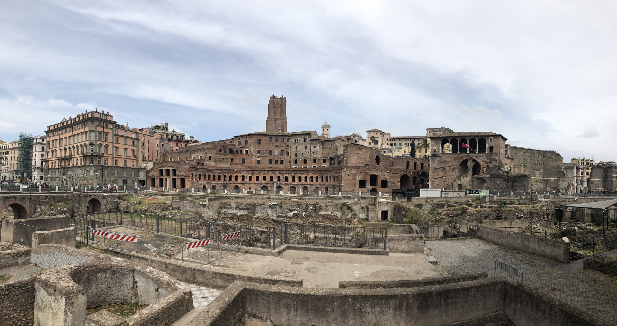 Ancient brick ruins of Trajan's Market stand against modern buildings in Rome, Italy