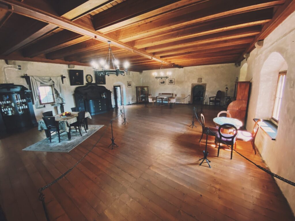 Spacious room with wooden ceilings and antique furniture inside Orava Castle