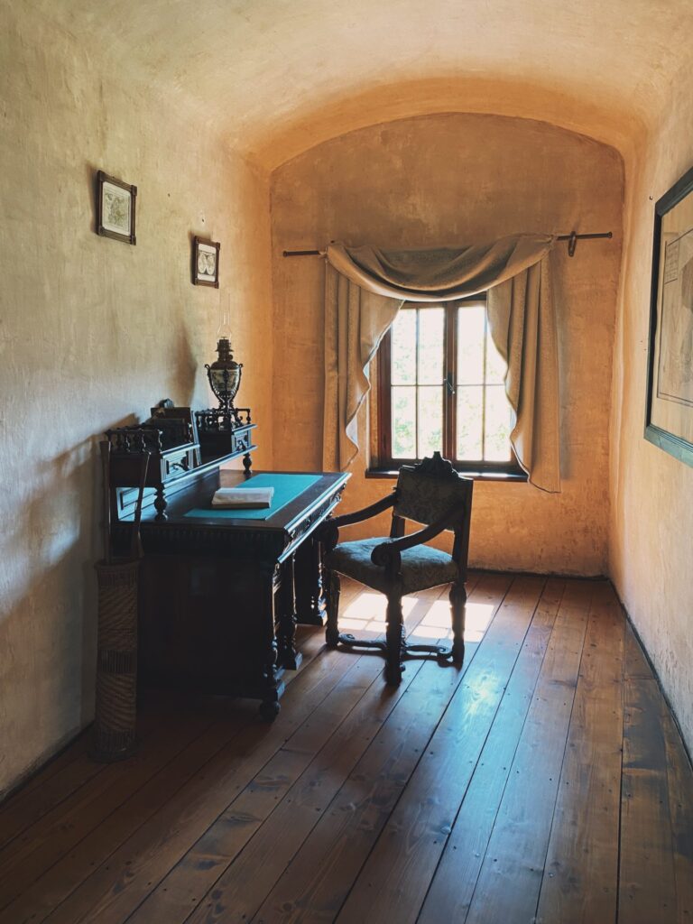 Antique desk and chair sit in a sunlit room at Orava Castle