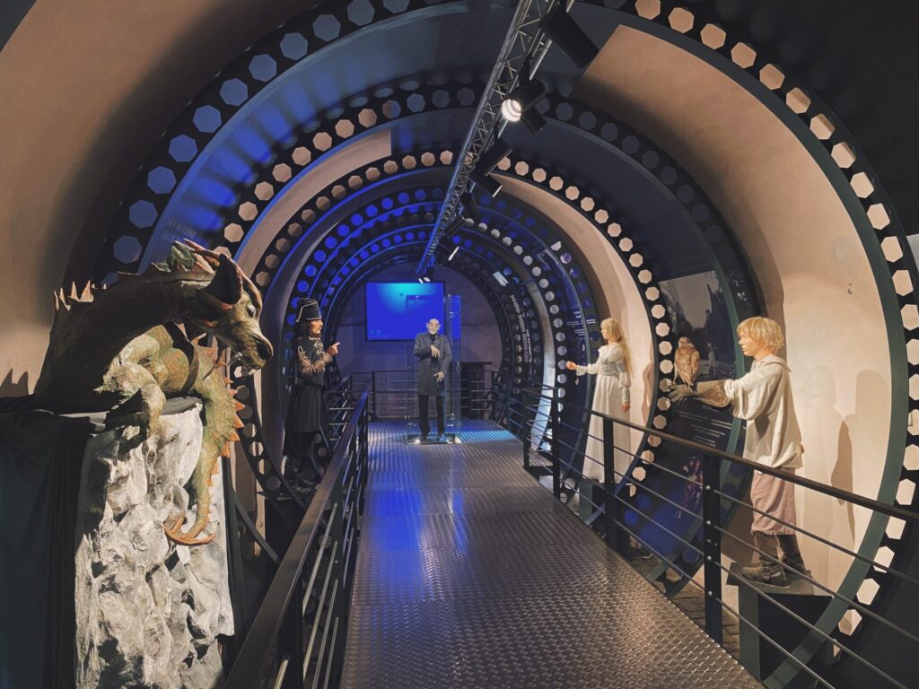 Life-sized figures and a dragon statue stand along a tunnel at Orava Castle