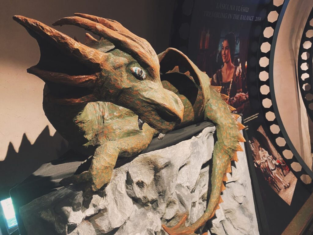 A green dragon sculpture on an indoor display stand inside Orava Castle