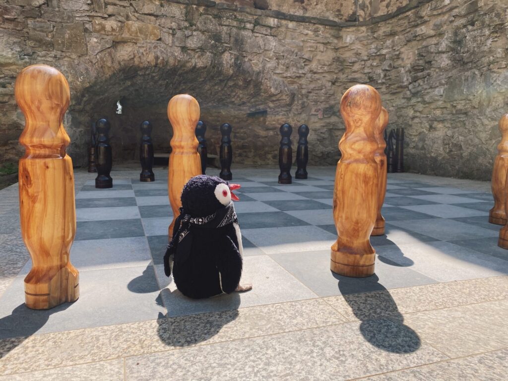 A plush penguin sits on a giant chessboard at Stará Ľubovňa Castle