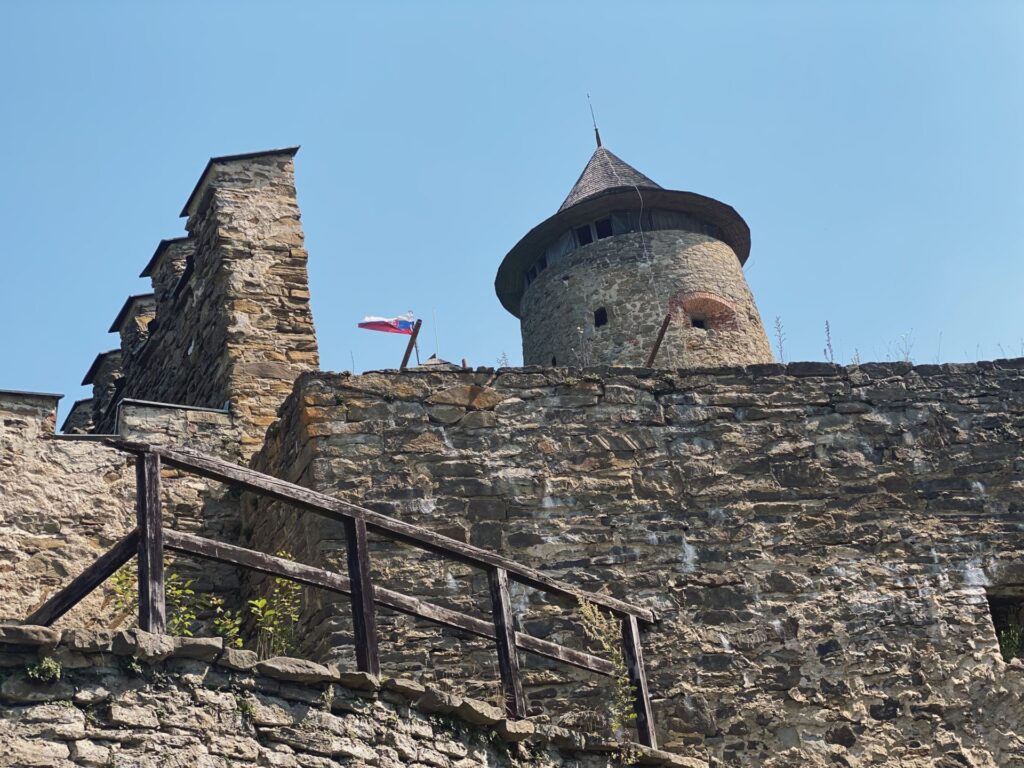 Stone walls and a tower at Stará Ľubovňa Castle under a clear sky