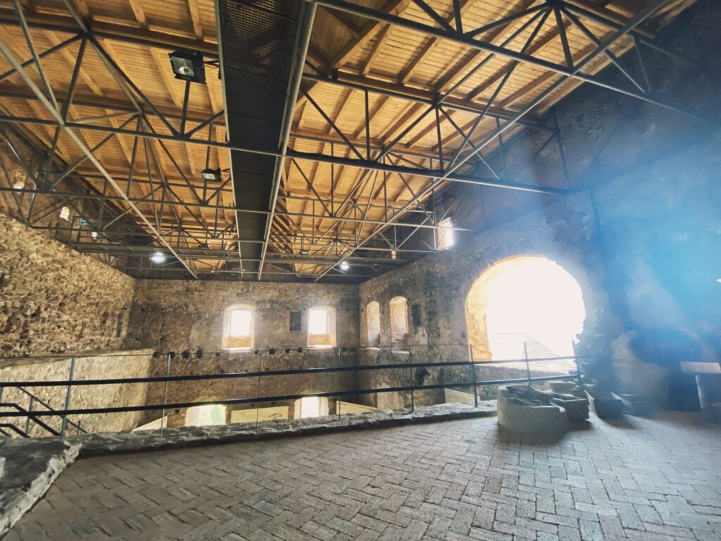 Sunlight streams into the stone interior of Stará Ľubovňa Castle under wooden rafters