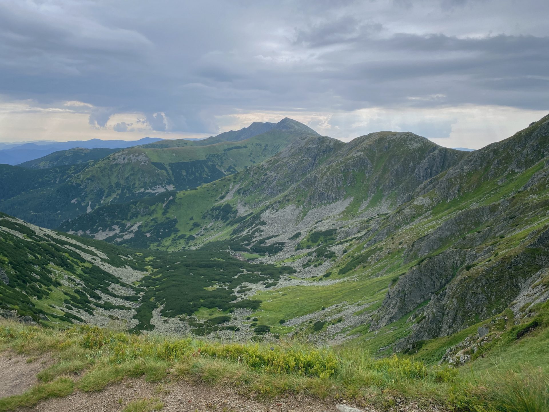 Green mountain slopes and rocky valleys under a cloudy sky in Low Tatras