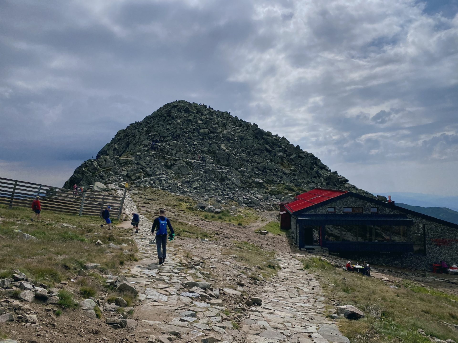 The rocky peak of Chopok with a stone path and a mountain hut nearby