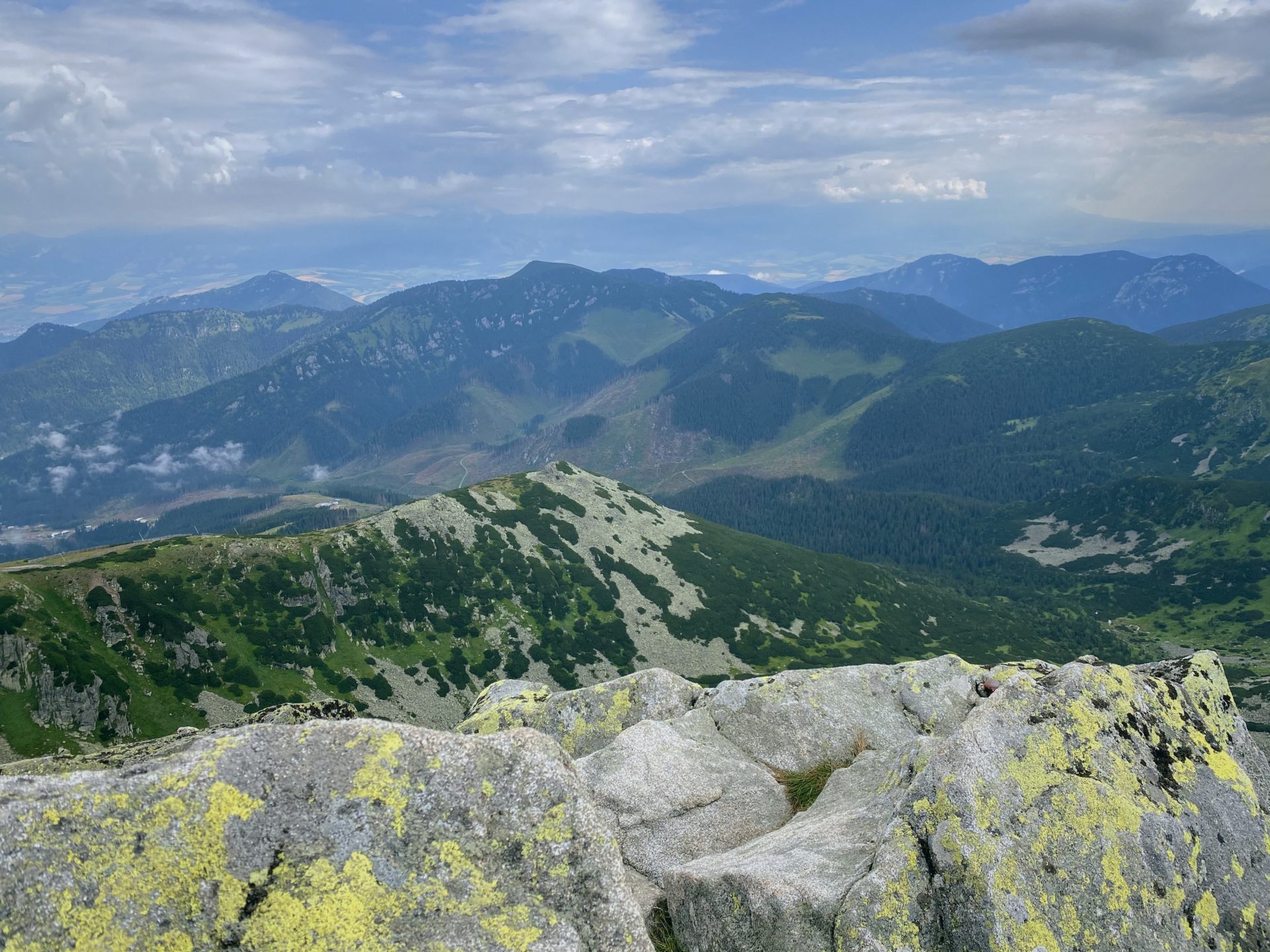 View from a rocky peak overlooking the green mountains of the Low Tatras