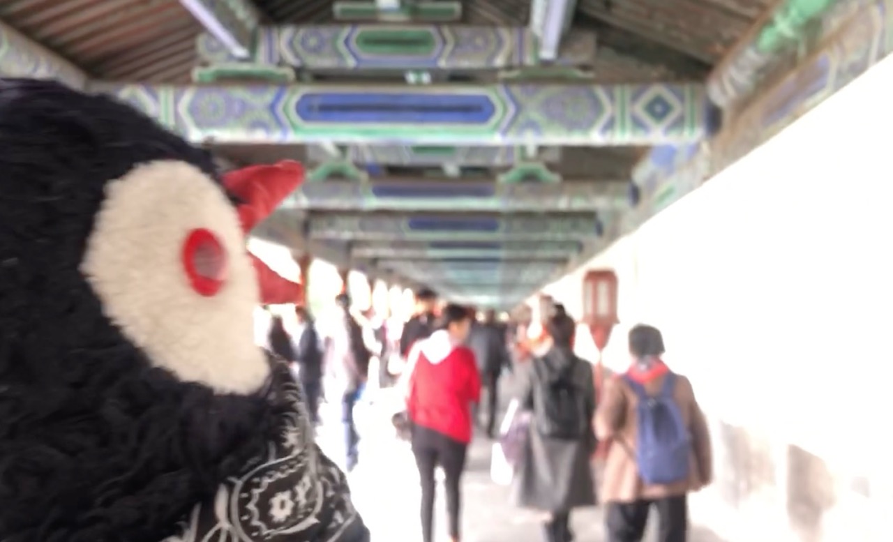 Plush toy in the foreground of a blurred walkway at the Temple of Heaven