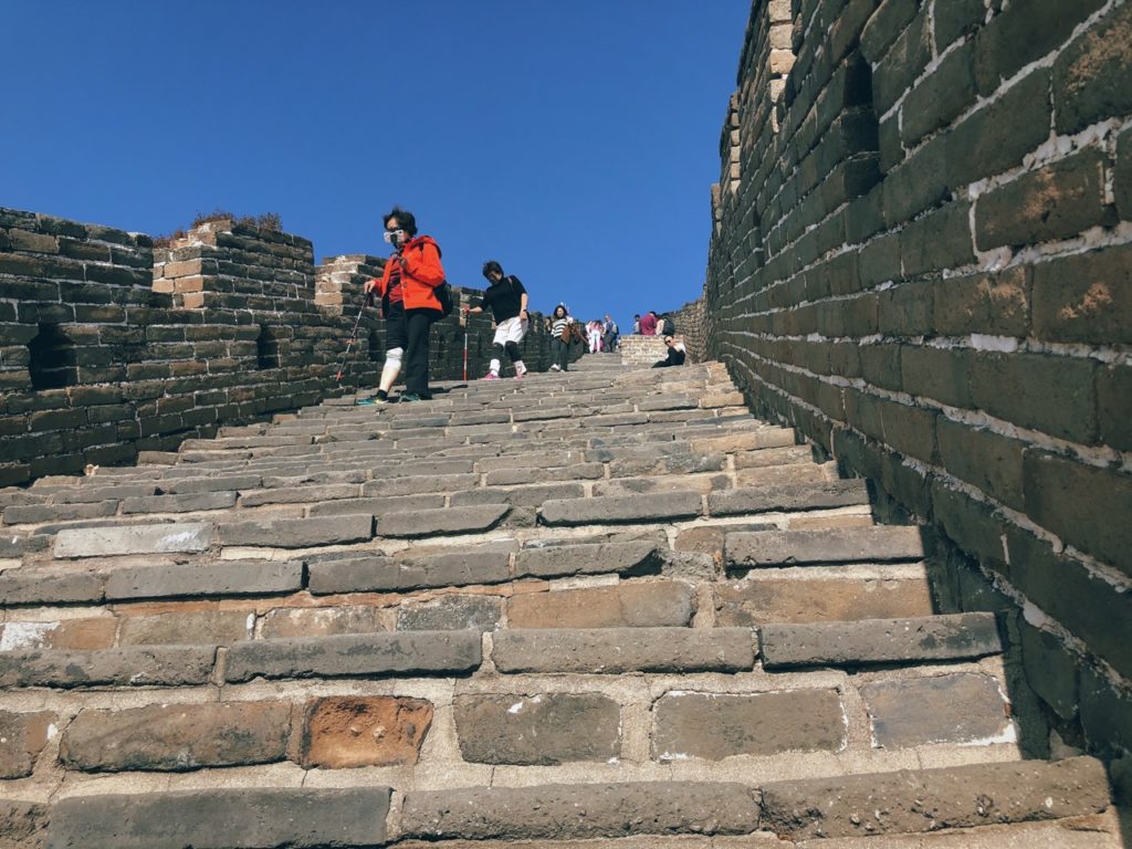 Tourists walk up the steep stone steps of the Great Wall of China
