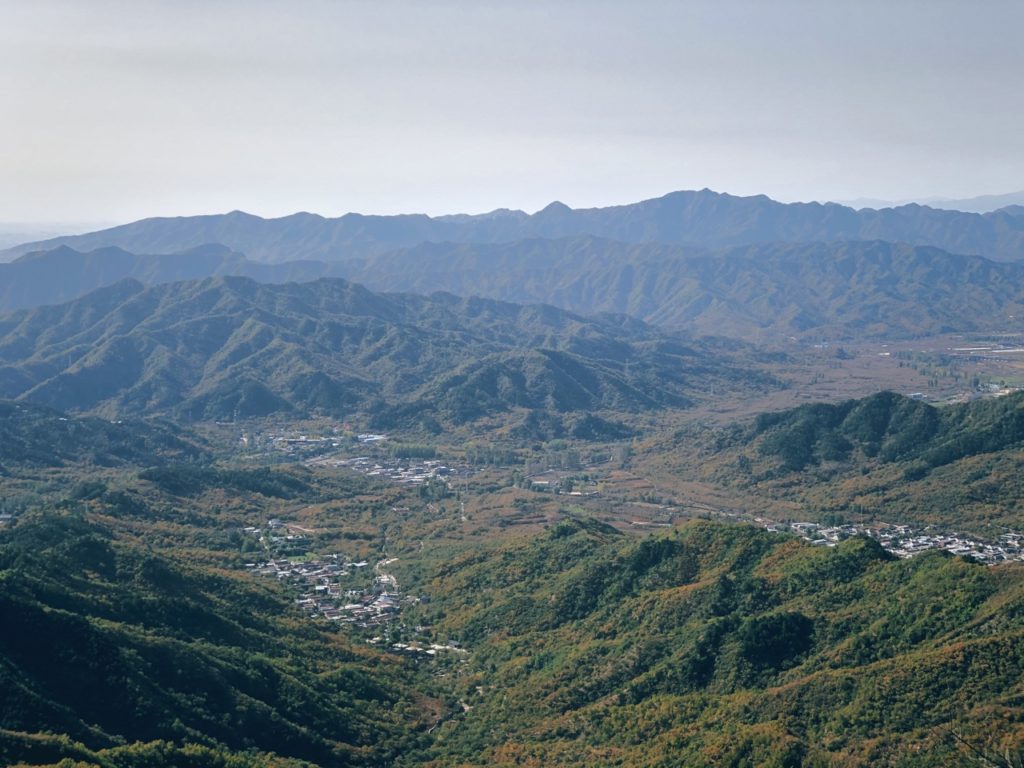 Small villages nestled in a valley surrounded by the Great Wall of China mountains