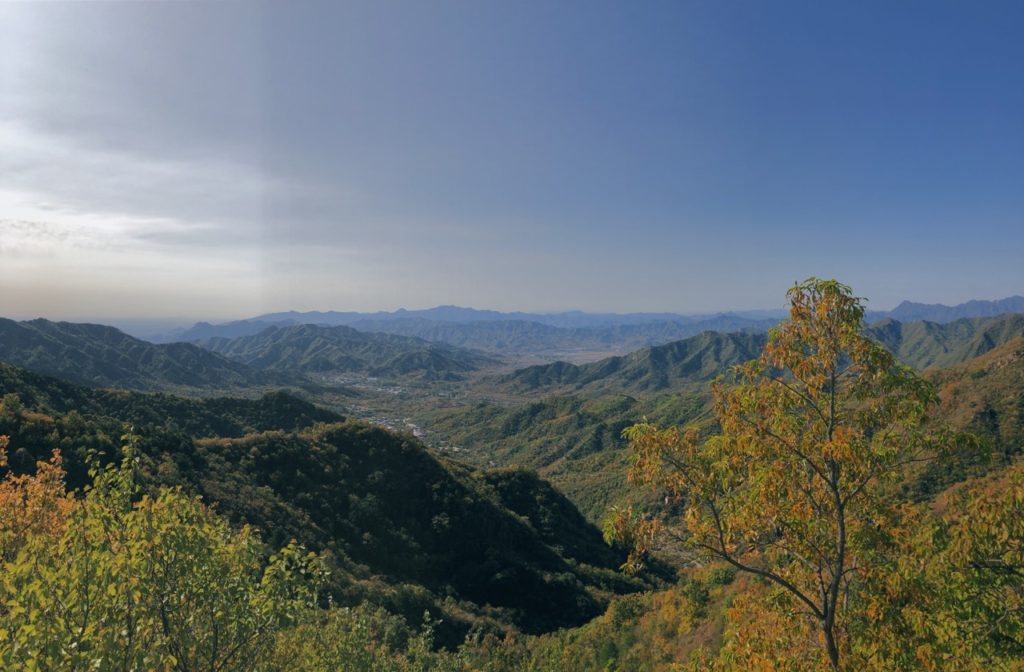 Rolling green mountains stretch toward the horizon under a clear blue sky