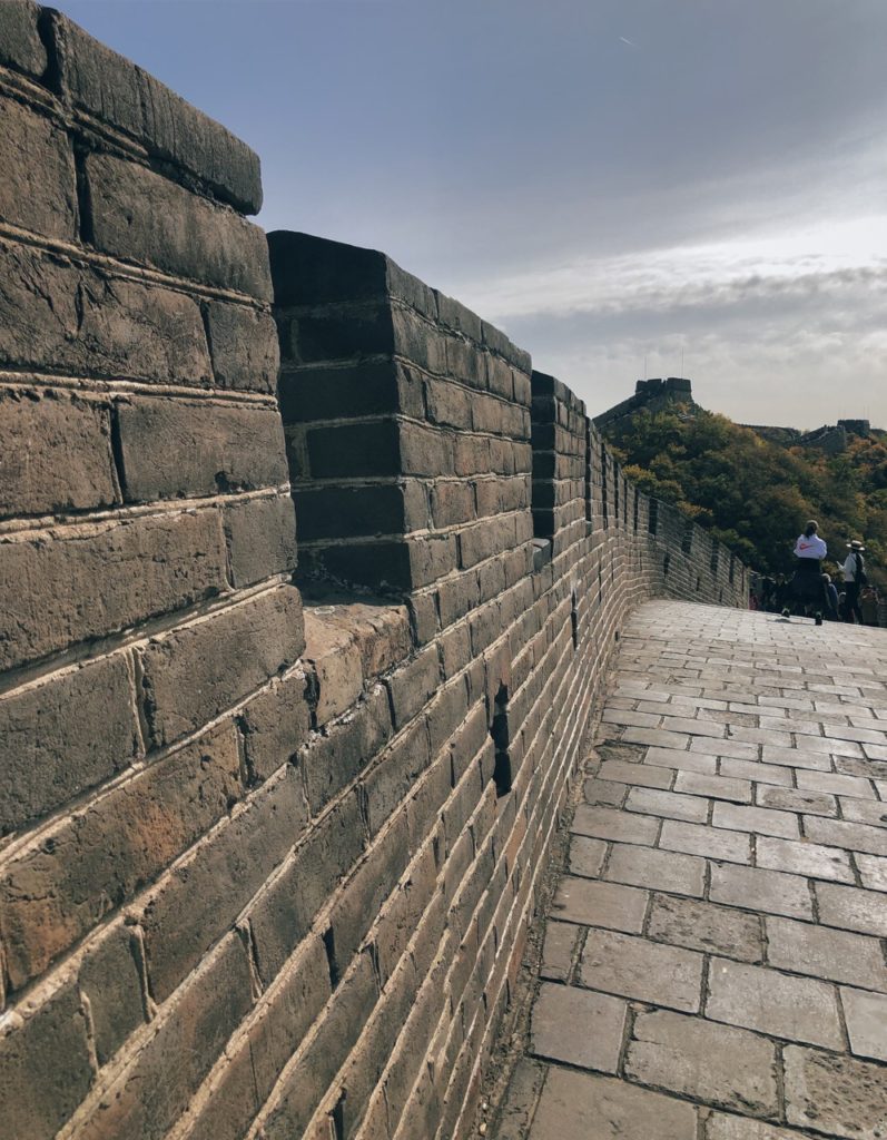 People walk along the stone path of the Great Wall of China