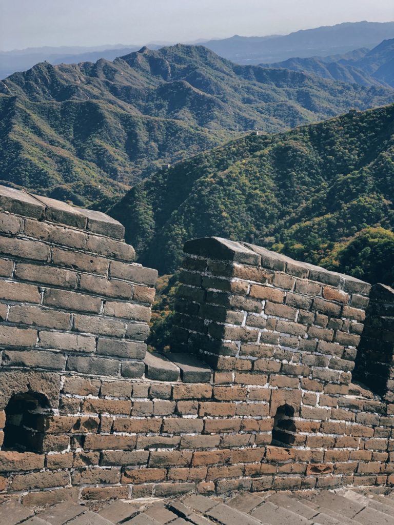 The Great Wall of China winds across lush green mountain ridges