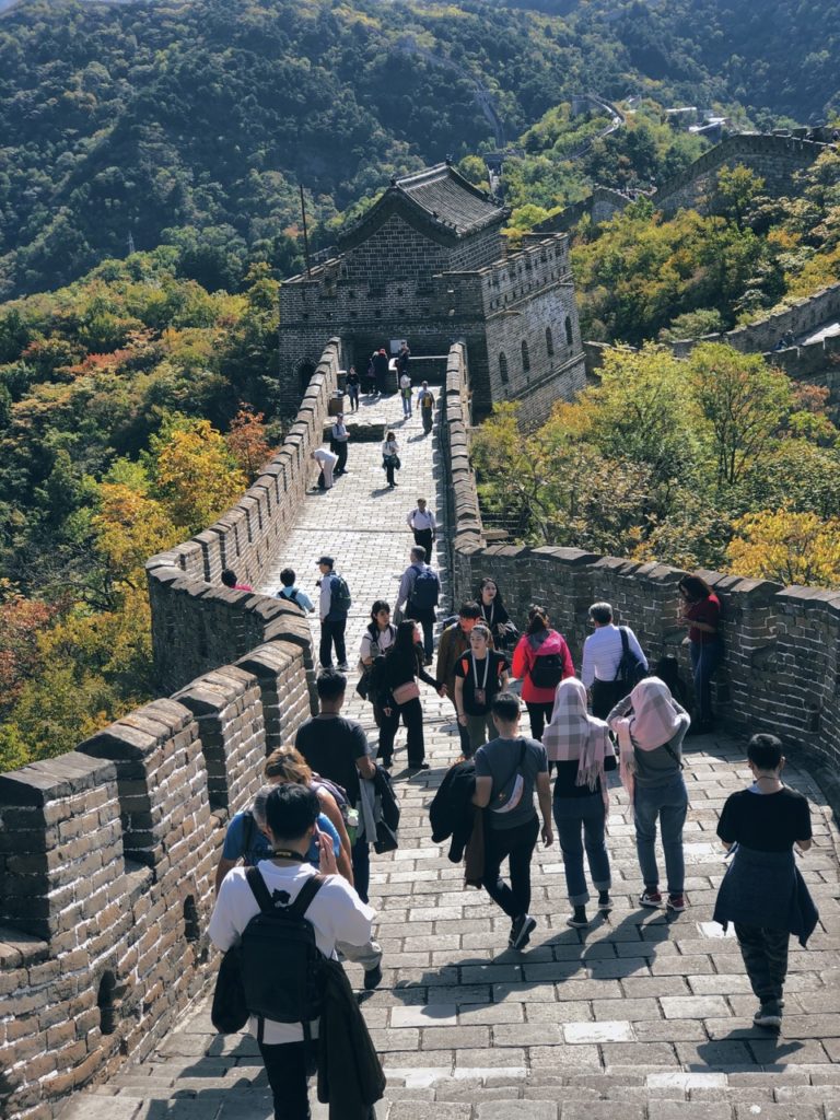 Tourists walk along the stone path of the Great Wall of China