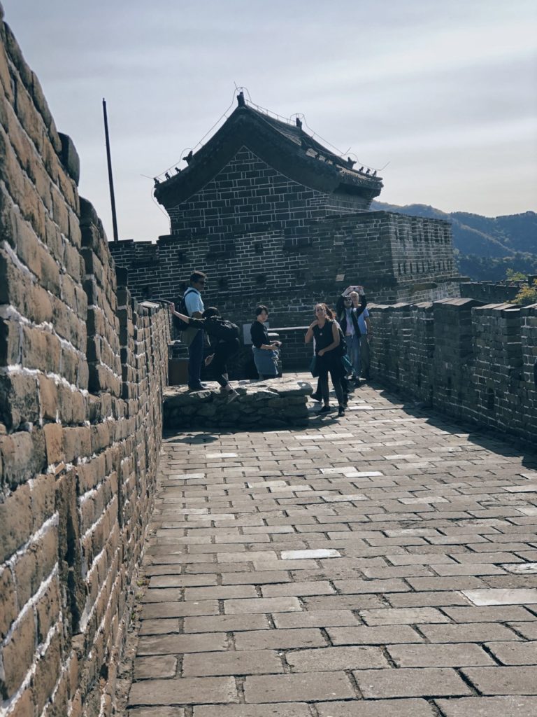 Tourists walk along the stone path of the Great Wall of China
