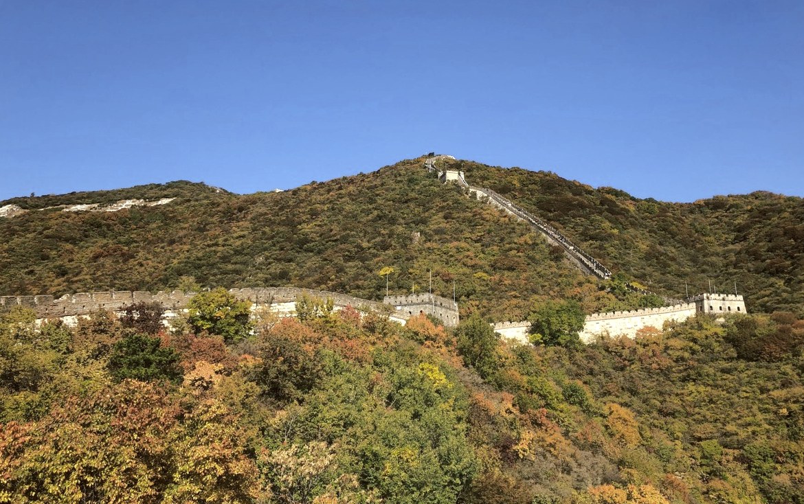 The Great Wall of China winding along a hillside in autumn colours