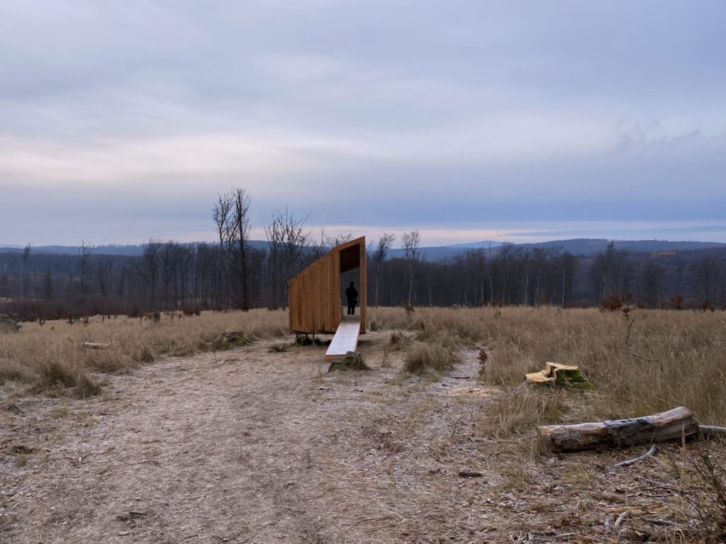 A person stands inside a wooden structure at the Vydrica Observatory