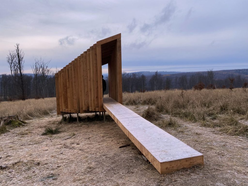 Wooden structure at the Vydrica Observatory overlooking a field and forest