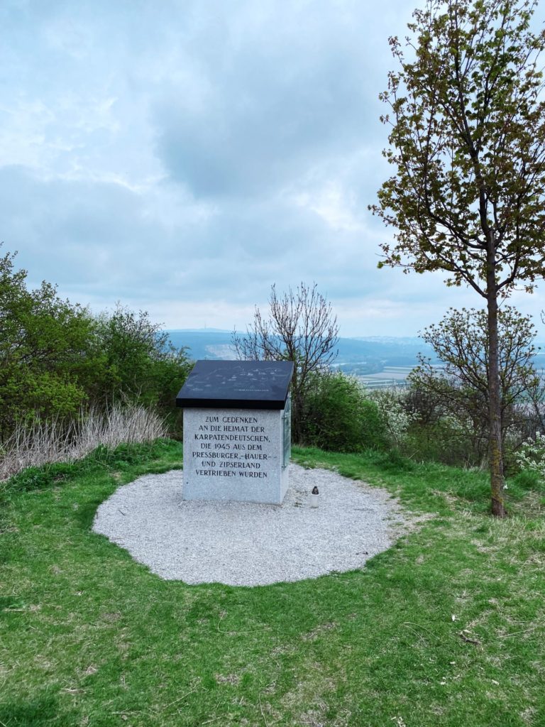 Memorial stone with German inscription on Braunsberg Hill overlooking a distant valley