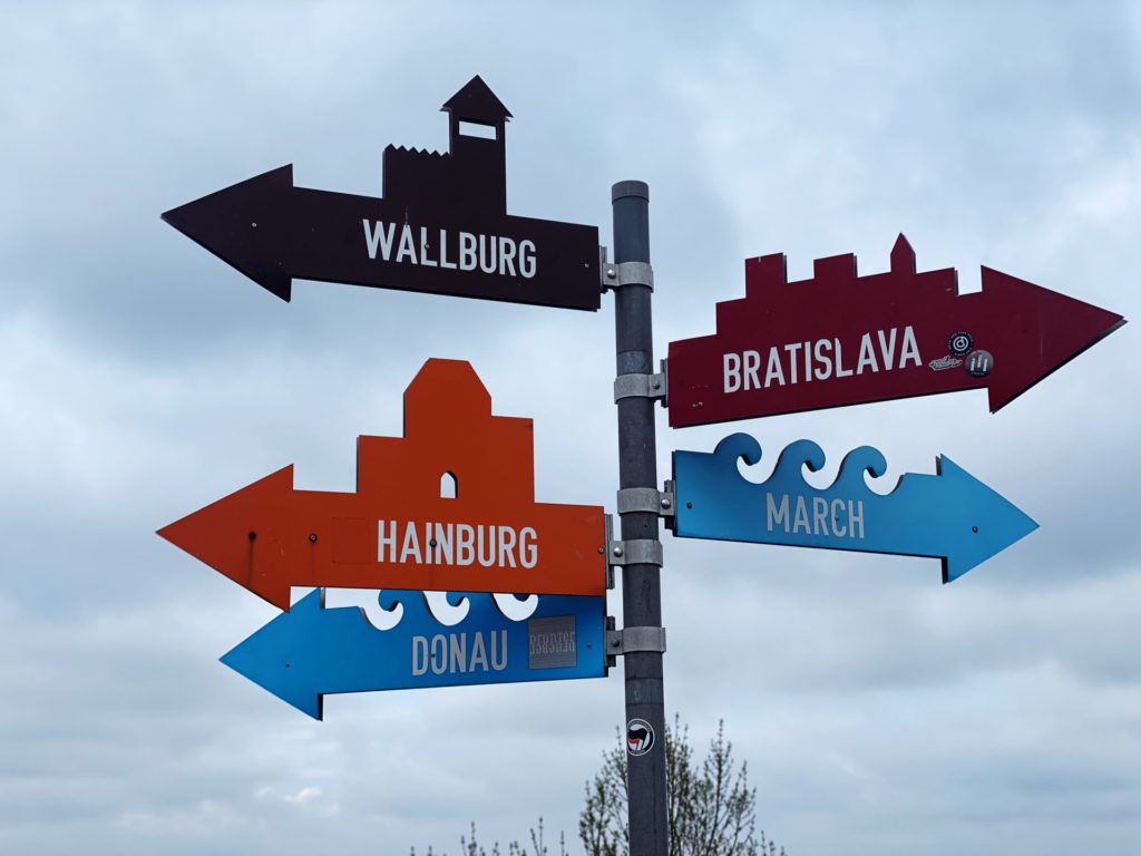 Colorful directional signs pointing toward Braunsberg Hill, Hainburg, Bratislava, and nearby rivers