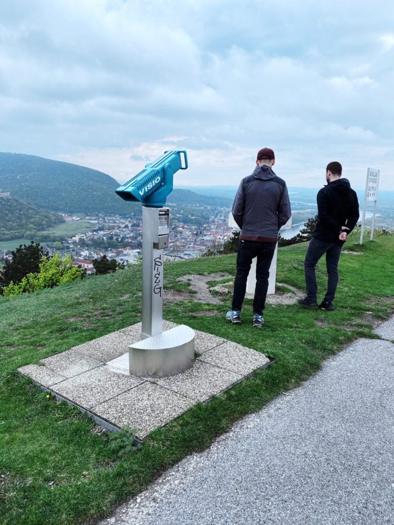 A coin-operated telescope stands on Braunsberg Hill as two men look out over the valley