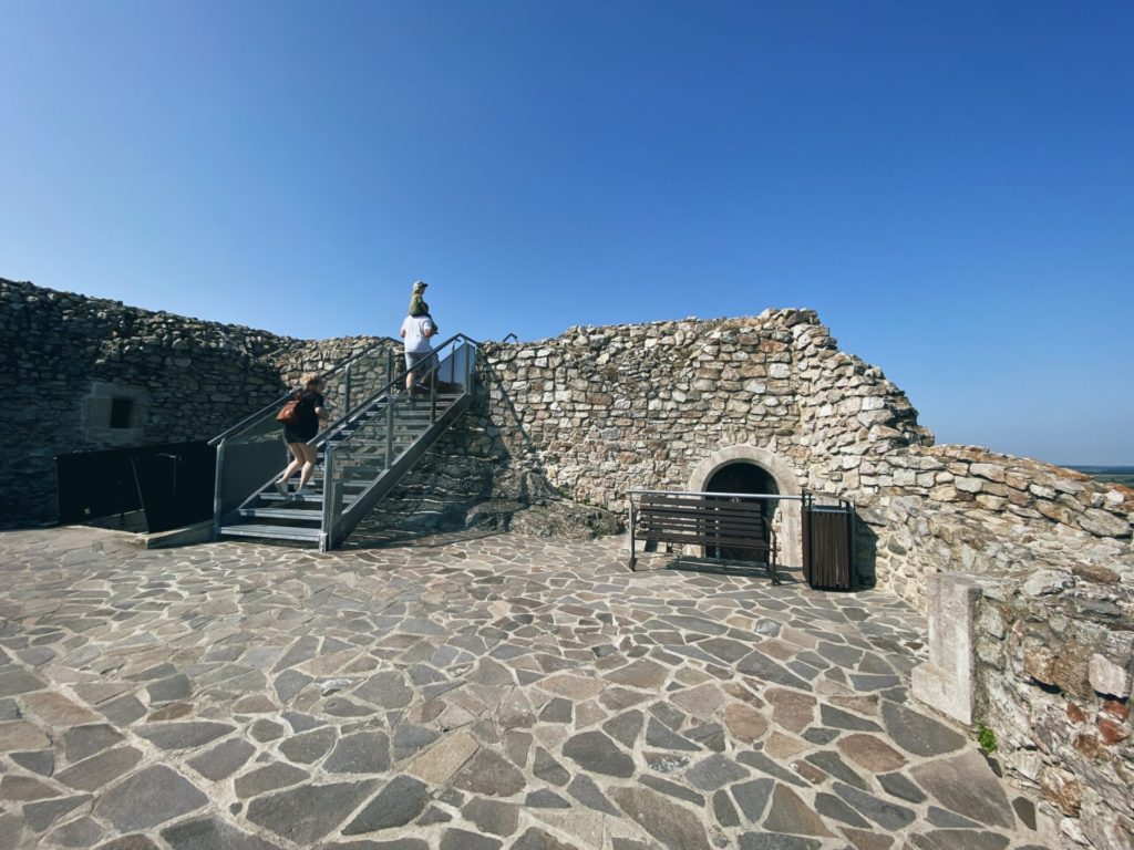 Visitors climb metal stairs at the stone ruins of Devín Castle