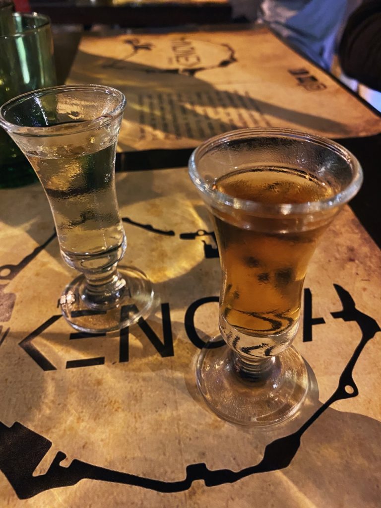 Two small glasses of amber liquid sit on a printed menu in Dubrovnik