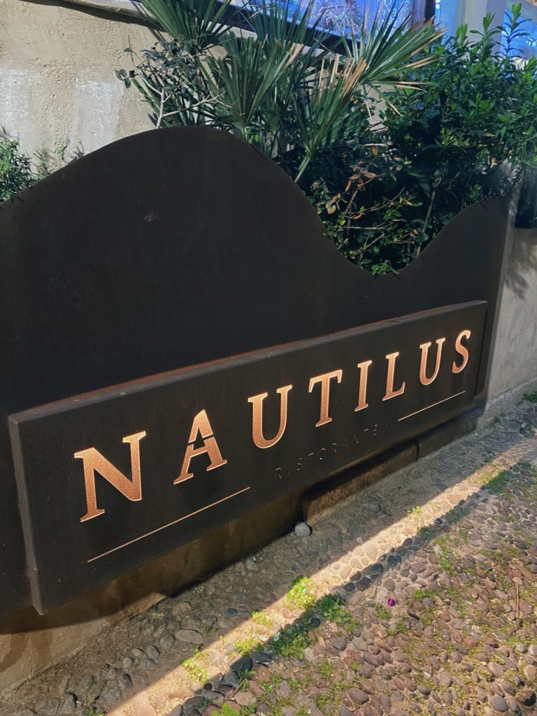Nautilus Ristorante sign mounted on a dark metal structure in Alghero