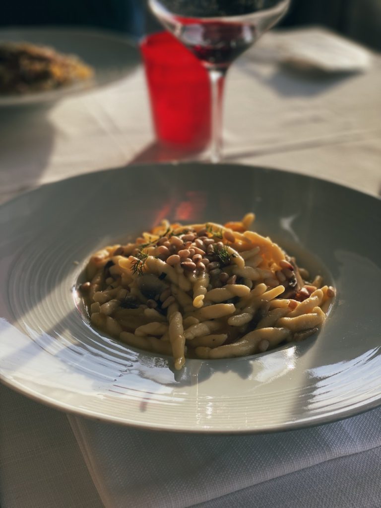Plate of pasta topped with pine nuts and herbs in Alghero, Sardinia