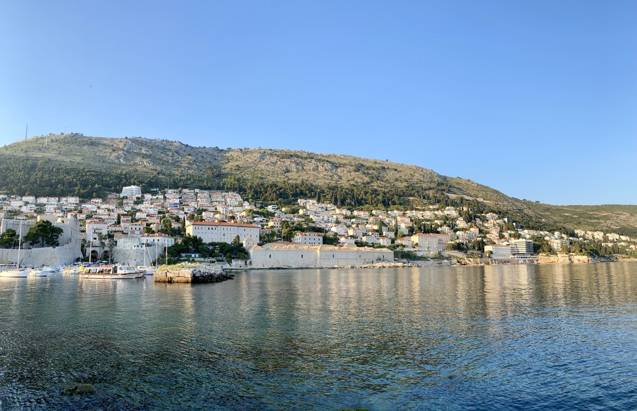 Panoramic view of Dubrovnik coastline with buildings on a hillside overlooking the sea