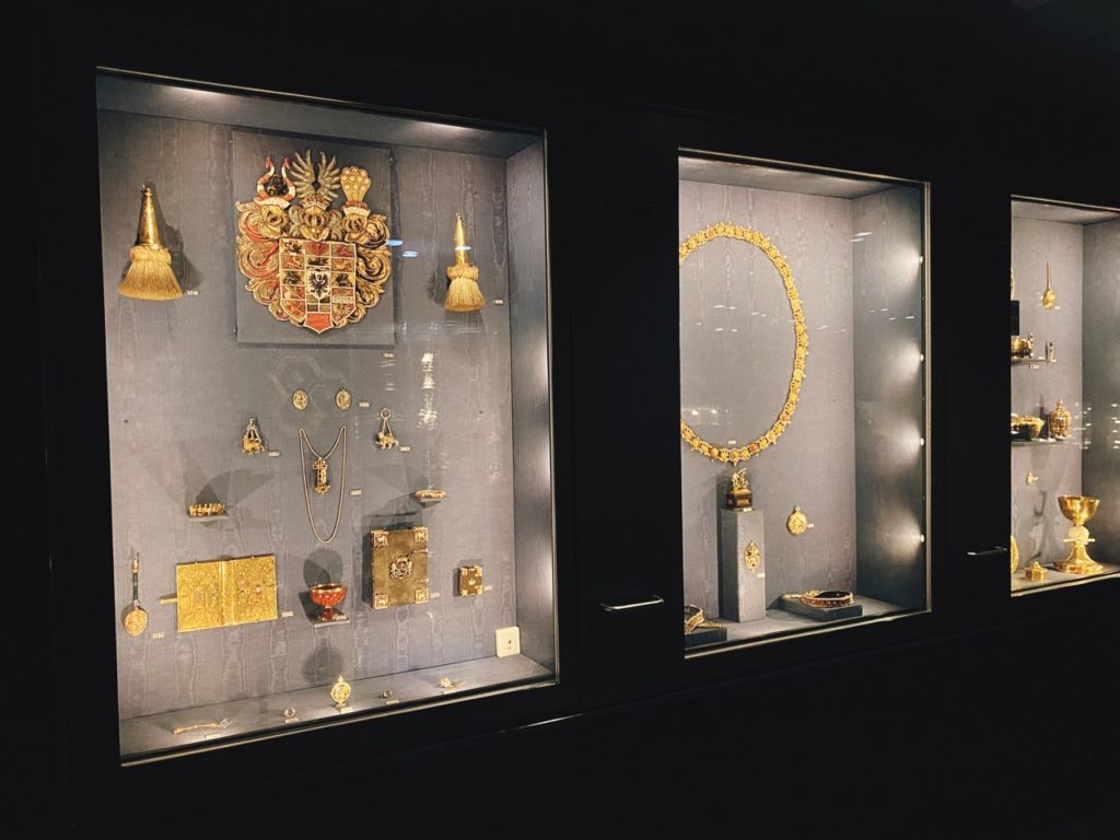 Ornate gold artifacts and jewelry displayed in glass cases at Rosenborg Castle
