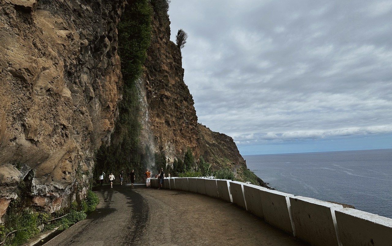 The old coast road at Cascata dos Anjos below a steep cliff, Madeira