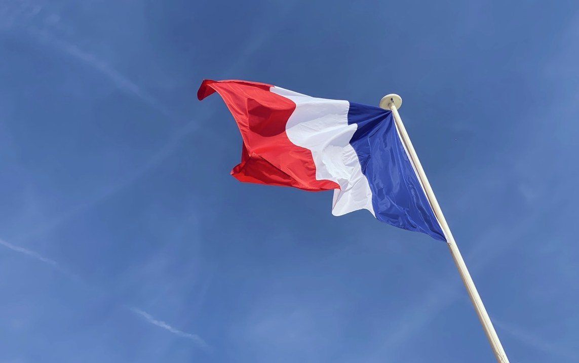 The French flag flying against a blue sky