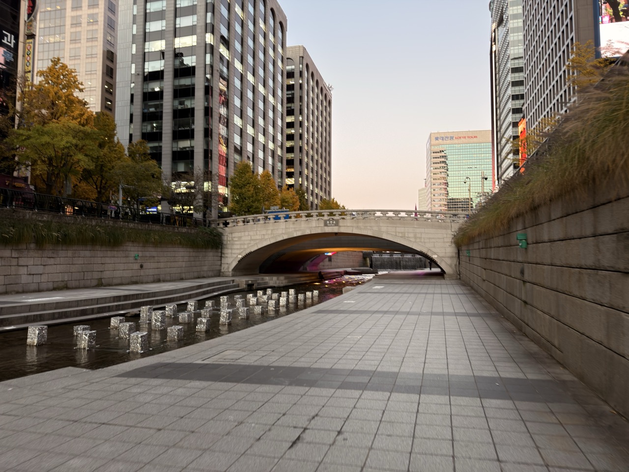 Stone bridge over the Cheonggyecheon stream in Seoul surrounded by modern buildings