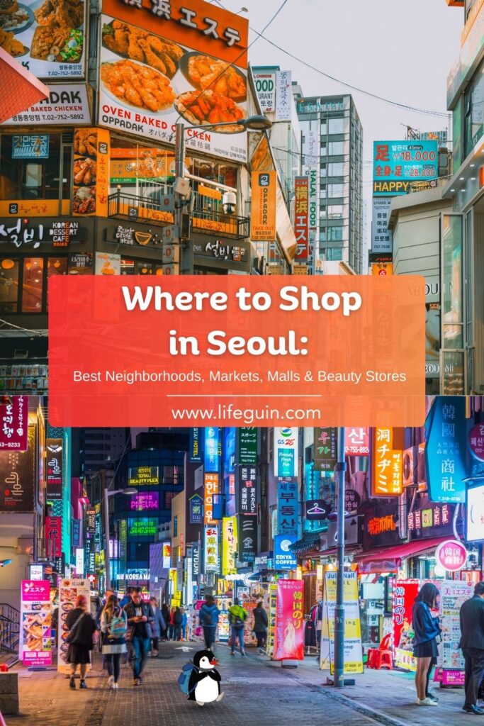 Bright neon signs illuminate a crowded shopping street in a bustling Seoul neighborhood
