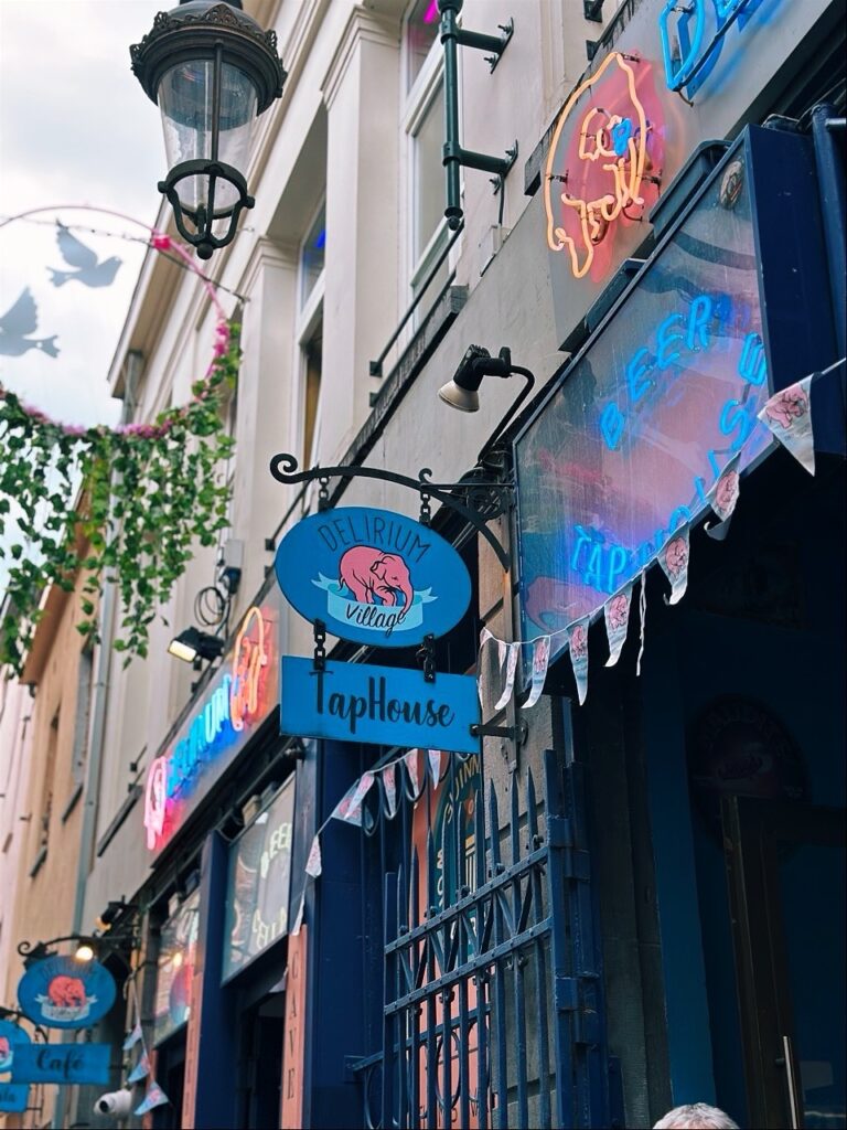 Blue signs and neon lights decorate the exterior of a Brussels taphouse