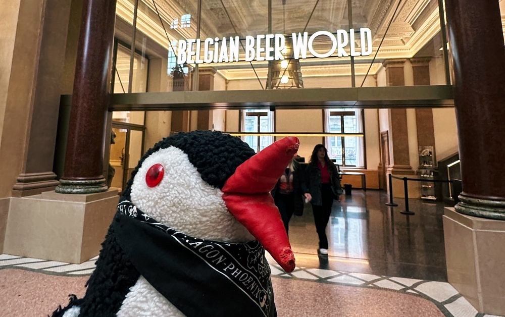 A plush penguin stands before the entrance to Belgian Beer World in Brussels