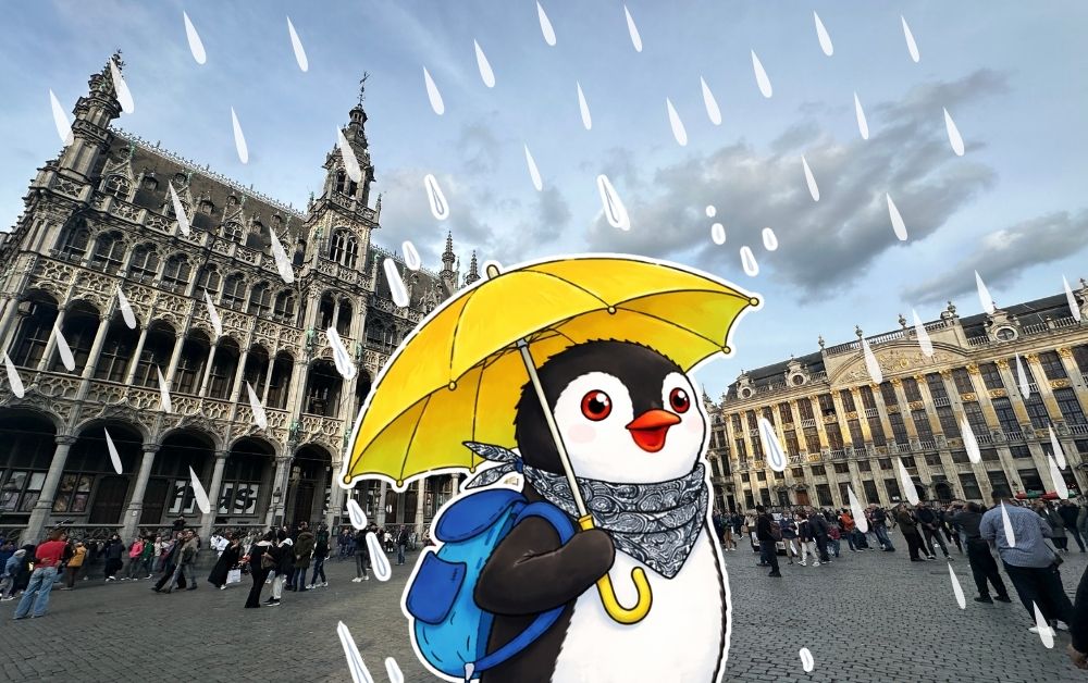 Miško the penguin holds a yellow umbrella in a rainy Brussels square with ornate buildings and people in the background
