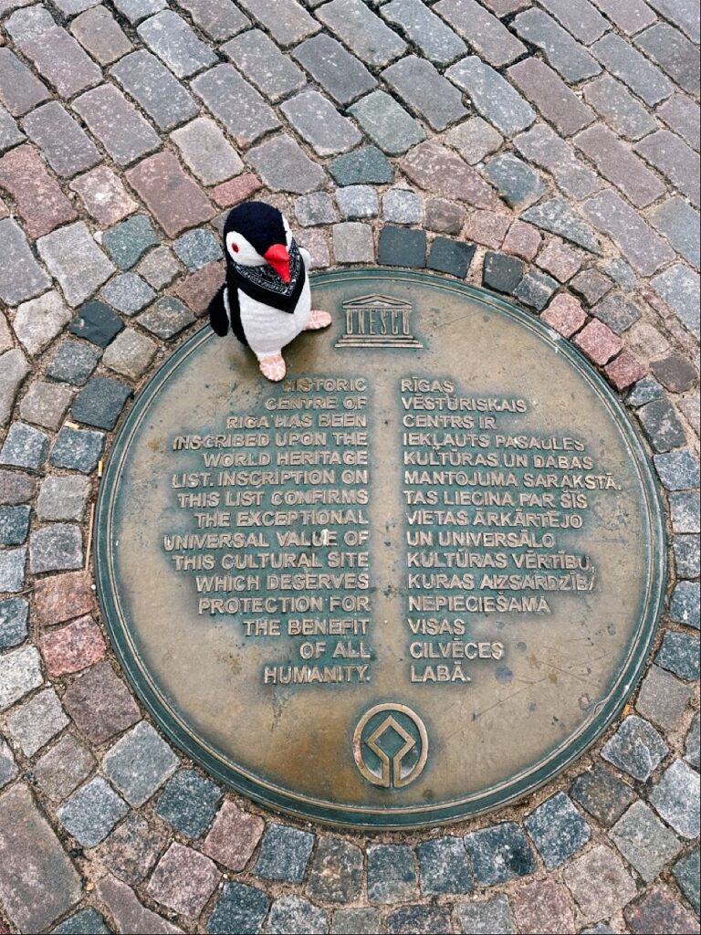 Stone plaque on a cobblestone wall displaying the UNESCO inscription for the historic centre of Riga