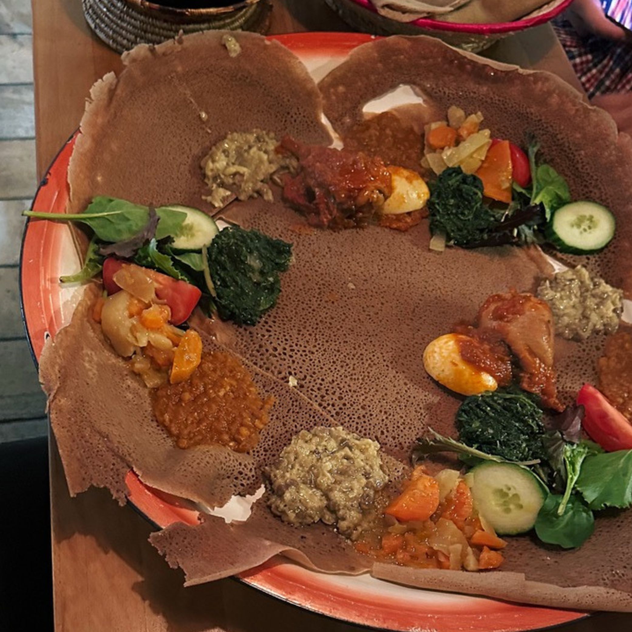 A large platter of Ethiopian injera bread topped with various stews and vegetables served at Lalibela Amsterdam