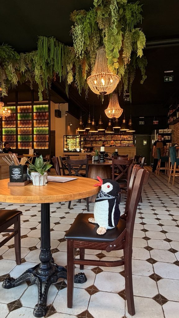 Brejk Bistro Prešov interior with wooden tables, chairs and a bar under pendant lighting